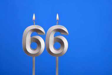 Birthday number 66 - Candle lit on blue background