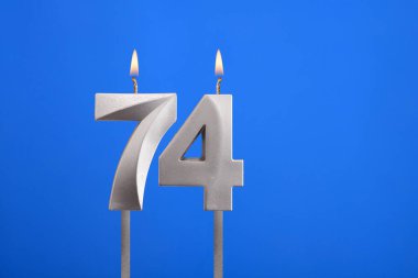 Doğum günü numarası 74 - Mavi arkaplanda mum yanıyor