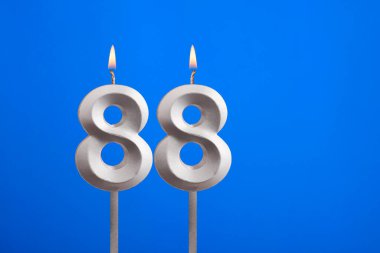 88 numaralı doğum günü - Mavi arkaplanda mum yanıyor