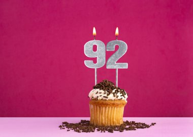 92 numaralı mumla doğum günü kutlaması - Pembe arka planda çikolatalı kek