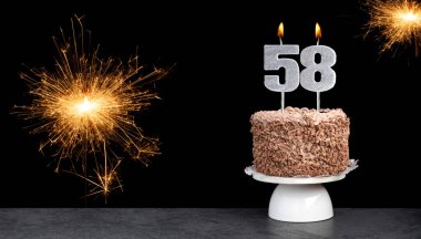 Pasta ve 58 numaralı mumla doğum günü kutlaması.