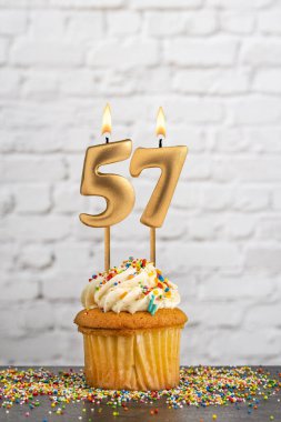 Altın doğum günü mumu 57 numaralı kek - Beyaz blok duvar arkaplanı