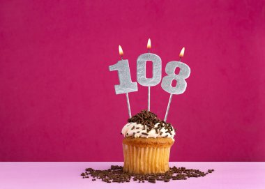 108 numaralı mumla doğum günü kutlaması - Pembe arka planda çikolatalı kek
