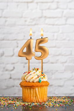 Altın doğum günü mumu 45 numaralı kek - beyaz blok duvar arka planı
