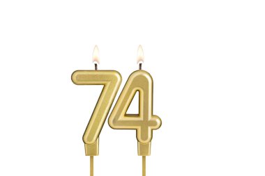 Beyaz arkaplanda 74 numaralı doğum günü mumu.
