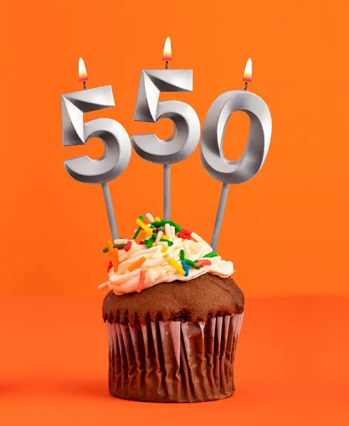 stock image Number 550 candle - Birthday cupcake on orange background