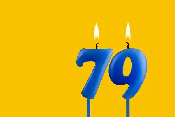 stock image Blue birthday candle on yellow background - Number 79