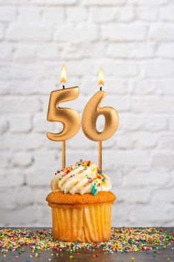 56 numaralı doğum günü mumlu kek - Beyaz blok duvar arkaplanı