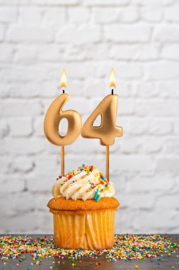 64 numaralı doğum günü mumlu kek - Beyaz blok duvar arkaplanı