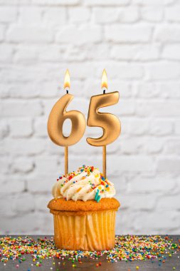 Altın doğum günü mumu 65 numaralı kek - Beyaz blok duvar arkaplanı