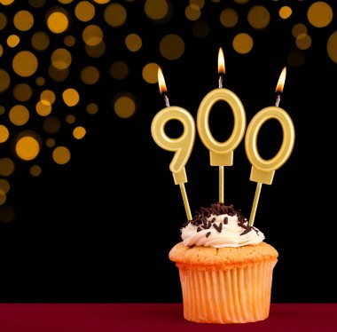 900 numaralı doğum günü mumu - Siyah arkaplanlı ve odak ışıkları olmayan kek