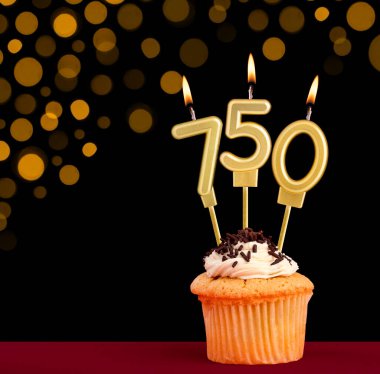 Kekli doğum günü mumu - 750 numara siyah arka planda odak ışıkları kapalı