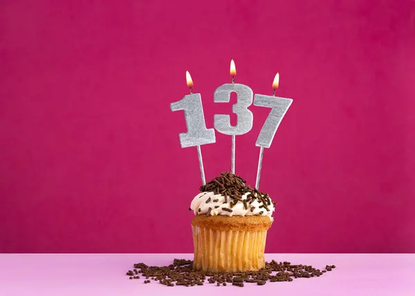 stock image Birthday cupcake with candle number 137 - Birthday card on pink background