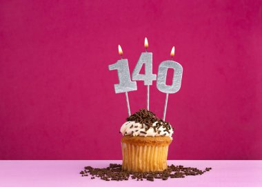 140 numaralı mumla doğum günü kutlaması - Pembe arka planda çikolatalı kek