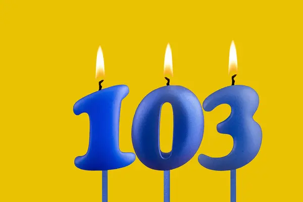 stock image Blue birthday candle on yellow background - Number 103