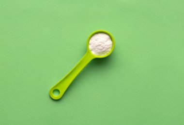 Kaşık içinde kabartma tozu - sağlıklı yiyecek. Yeşil arkaplan