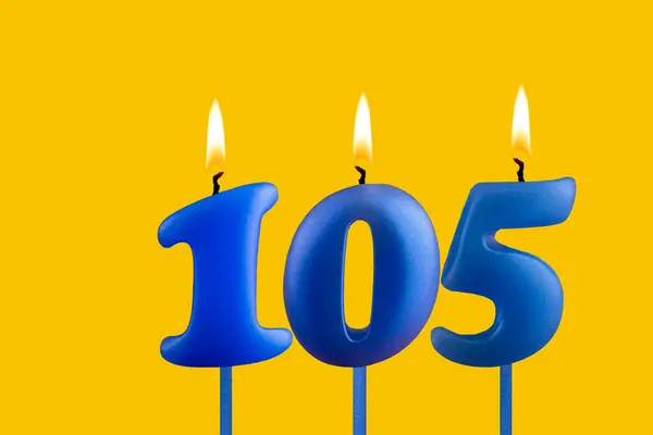 stock image Blue birthday candle on yellow background - Number 105