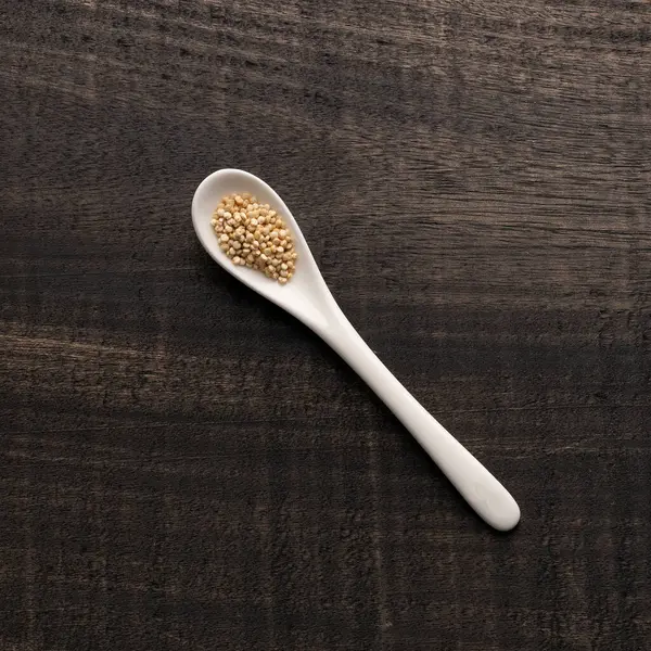 Chenopodium kinoası - kaşıkta beyaz organik kinoa tohumu - Rustik arkaplan