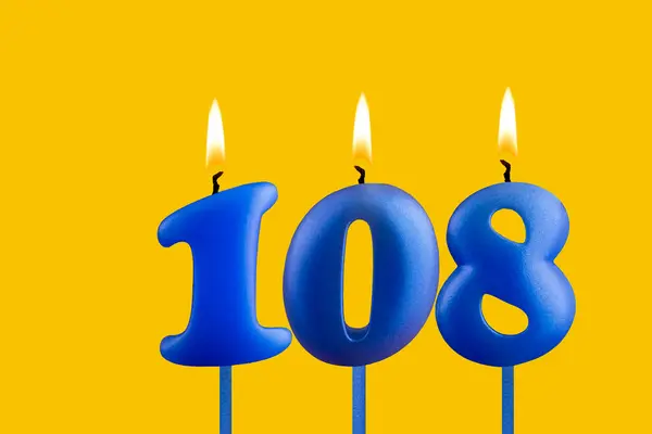 stock image Blue candle number 108 - Birthday on yellow background