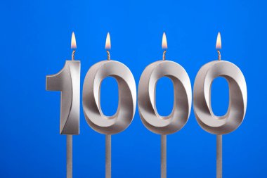 1000 numaralı doğum günü mumu - Mavi arka planda kutlama kartı