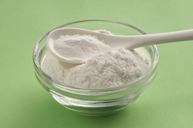 Kaşık ve kâsede kabartma tozu sağlıklı yiyecekler. Yeşil arkaplan