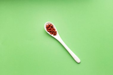 Kırmızı organik annatto tohumları kaşıkta - Bixa Orellana