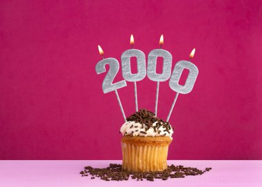 2000 numaralı mumla doğum günü kutlaması - Pembe arka planda çikolatalı kek