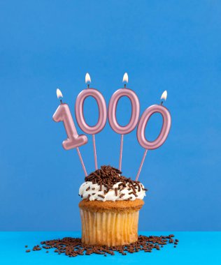 Mavi arka planda kek olan doğum günü mumu - 1000 numara