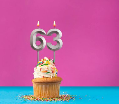 63 numaralı doğum günü mumlu kek - Mavi ve mor arka planda yıldönümü kartı