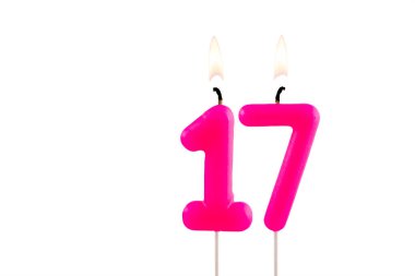 Beyaz arkaplanda 17 numaralı pembe doğum günü mumu.