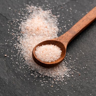 İnce pembe tuz serpiştirilmiş Güzel Himalaya kristalleri kaşıkta.