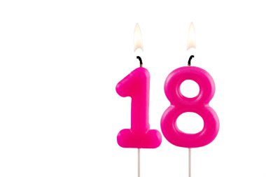 18 numaralı pembe doğum günü mumu beyaz arka planda yanıyor.