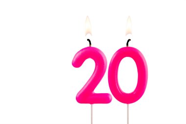 20 numaralı pembe doğum günü mumu beyaz arka planda yanıyor.