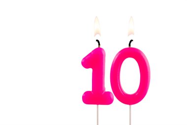 10 numaralı pembe doğum günü mumu beyaz arkaplanda yanıyor.