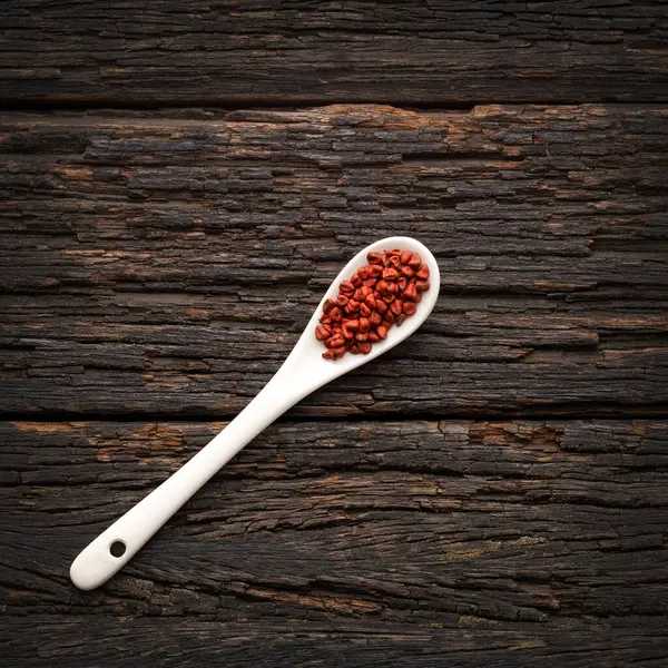 stock image Organic red annatto seeds in the spoon - Bixa Orellana