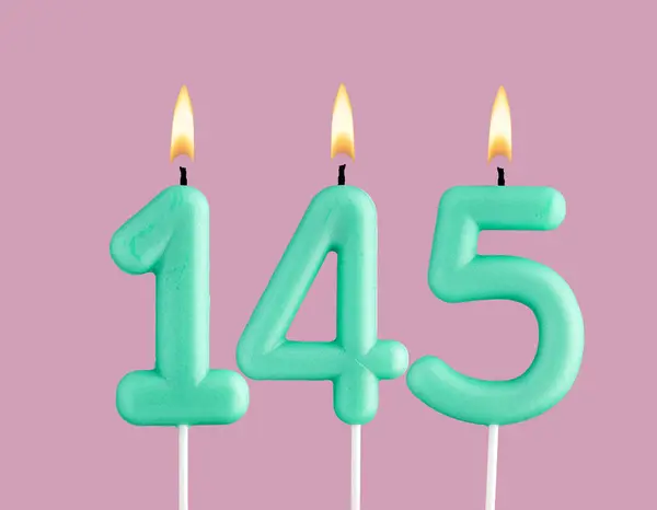 stock image Birthday card with green number 145 candle - Pastel pink background