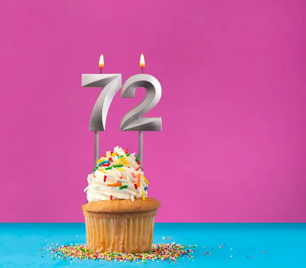 stock image Lit birthday candle with the number 72 - Celebration card on violet and blue background