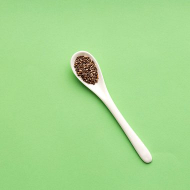 Kaşıktaki organik taze chia tohumları - Salvia Hispanica. yeşil arkaplan