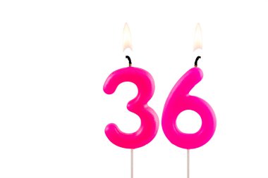 Pembe numara 36. Doğum günü mumu beyaz arka planda yanıyor.