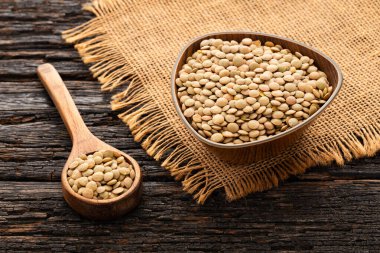 Kase ve kaşıkta çiğ kahverengi mercimek..