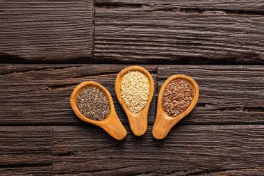 Kaşıklara organik chia, keten tohumu ve kinoa tohumu - Linum usitatissimum, Salvia hispanica ve Chenopodium kinoa.