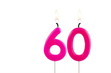 Beyaz arkaplanda 60 numaralı pembe doğum günü mumu yanıyor.