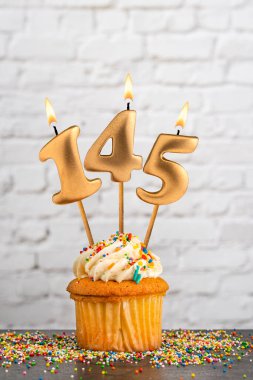 Altın doğum günü mumu 145 numaralı kek - beyaz blok duvar arkaplanı
