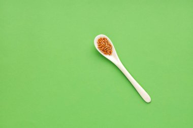 Sinapis alba - Yellow mustard seeds in spoon. clipart