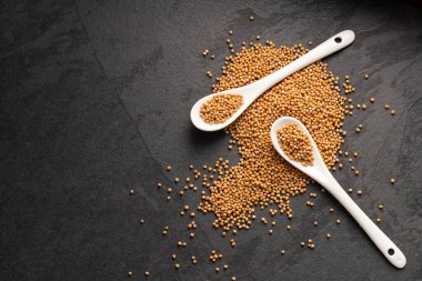 Sinapis alba - Yellow mustard seeds in two spoons. clipart