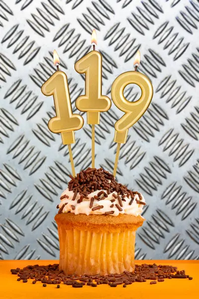 stock image Chocolate cupcake with candle number 119 - Birthday on industrial metallic background.