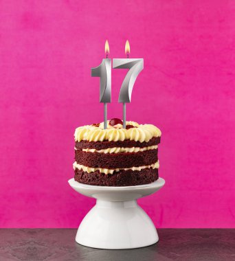17 numaralı mumlu doğum günü pastası fuşya arka planında kırmızı kadife..