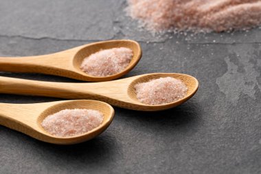 Himalayan pink fine salt in various spoons - Fine crystals sprinkled. clipart