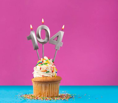 104 numaralı doğum günü mumunu yak - Menekşe ve mavi arka planda kutlama kartı