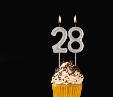 28 numara mumlar - Siyah arkaplanda doğum günü pastası.